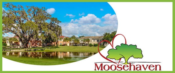 Photo of buildings by a tree-lined lake next to the Moosehaven logo